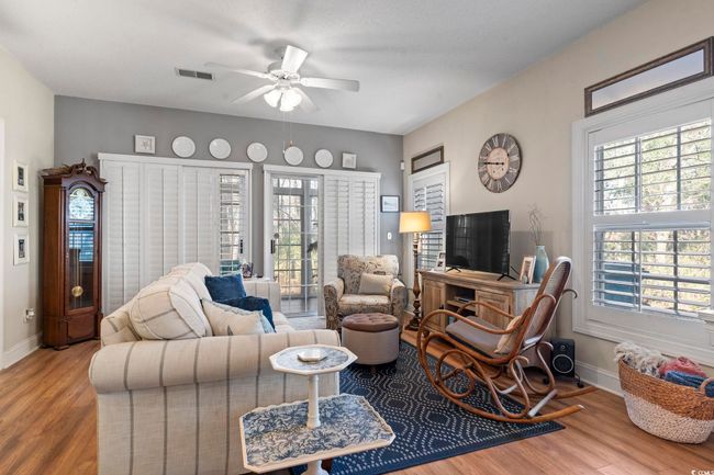 Living room with wood finished floors, baseboards, ceiling fan, and visible vents | Image 20