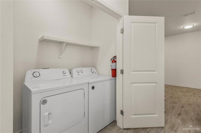 Laundry room featuring washer and dryer and light wood-type flooring | Image 8
