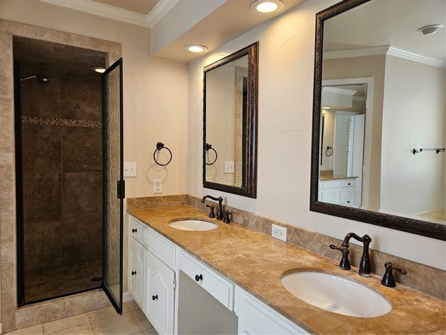 Full bathroom featuring double vanity, ornamental molding, a shower stall, and tile patterned floors | Image 12