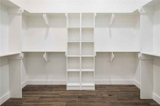 Spacious closet with dark wood-style floors | Image 16