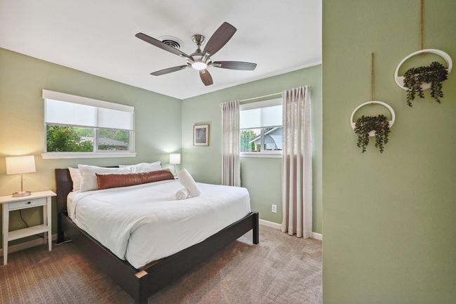 One of three secondary bedrooms, this bright and spacious room is infused with natural light from windows on two walls. | Image 26
