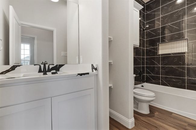 Full bathroom with shower combination, vanity, toilet, and wood finished floors | Image 18