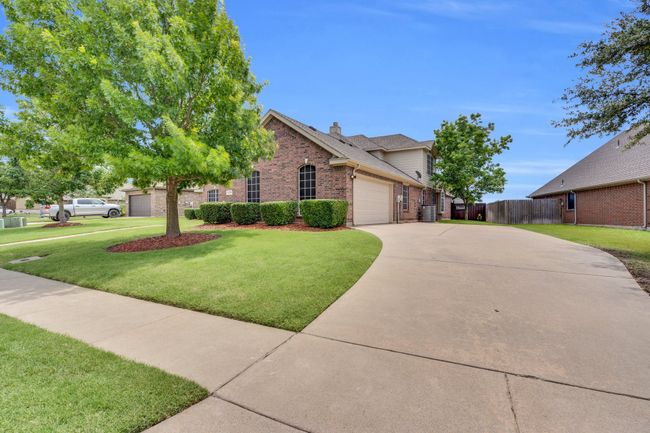 View of front of home featuring brick siding, driveway, a garage, and a chimney | Image 36