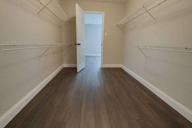 Spacious closet featuring dark wood finished floors | Image 11