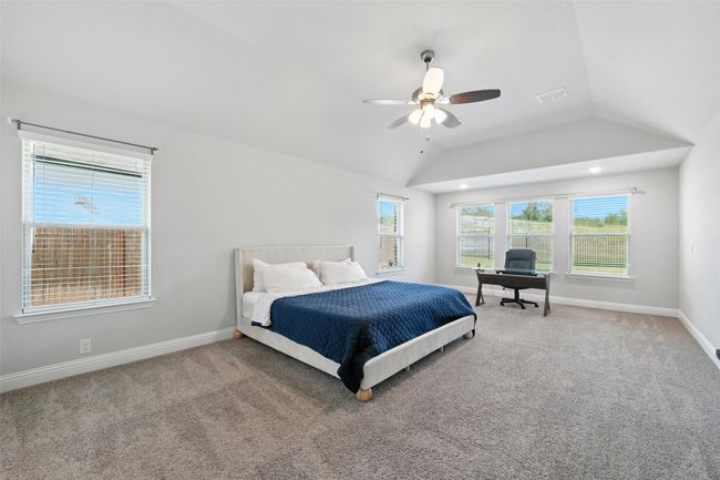 Carpeted bedroom featuring lofted ceiling, an office area, and a ceiling fan | Image 19