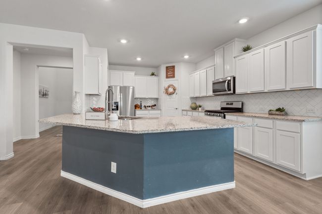 Eat In Kitchen with Massive Island, stainless steel appliances, a sink, white cabinets, backsplash, and light stone countertops | Image 10