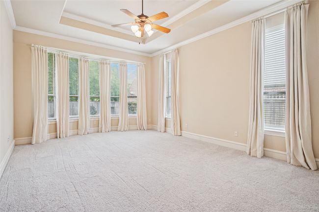 Primary bedroom with new carpet, trey ceiling and custom window treatments. | Image 19