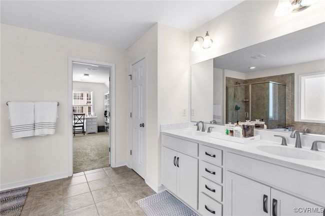 Tile floor, raised dual sink vanity, soaking tub, separate shower, water closet and oversized walk in closet with built in organization | Image 23