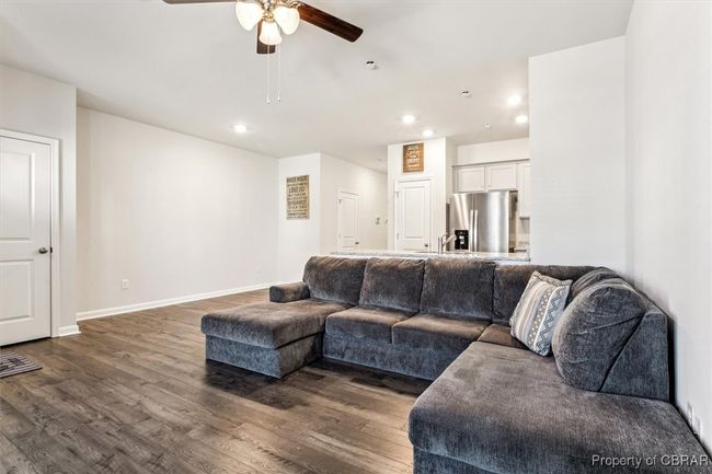 Living room featuring baseboards, recessed lighting, dark wood-type flooring, and ceiling fan | Image 10