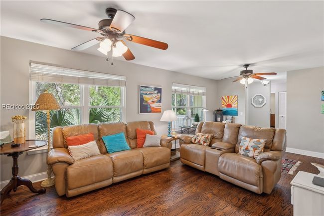 Primary living room with hardwood floors, ample seating, bright natural lighting, smooth ceilings. | Image 35