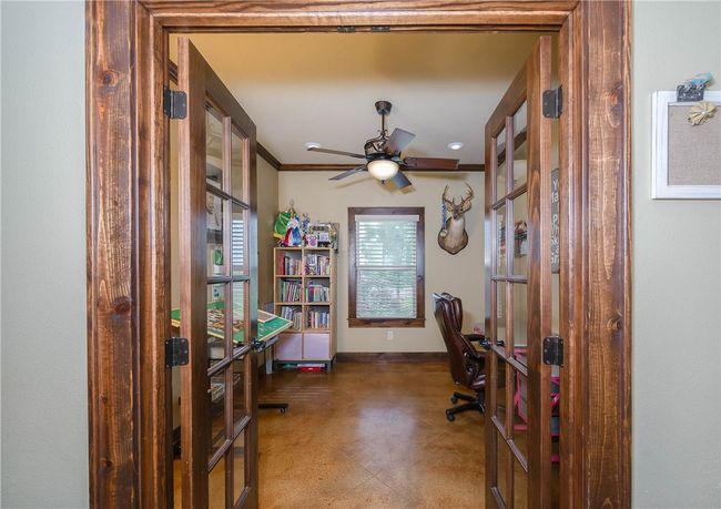 Office featuring finished concrete floors, ceiling fan, french doors, baseboards, and ornamental molding | Image 13