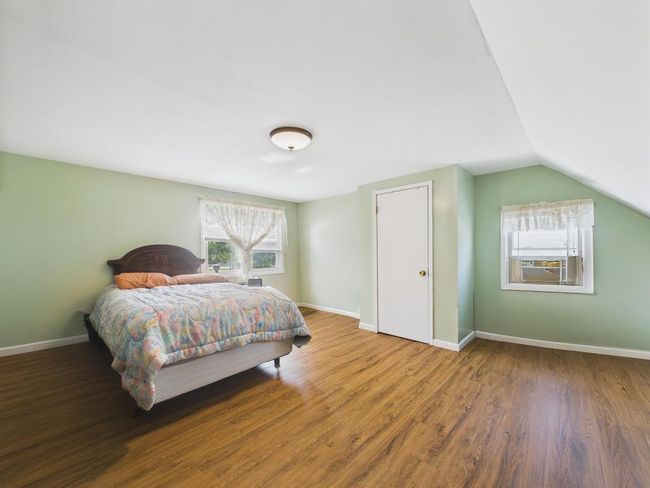 Bedroom featuring wood finished floors and vaulted ceiling | Image 14