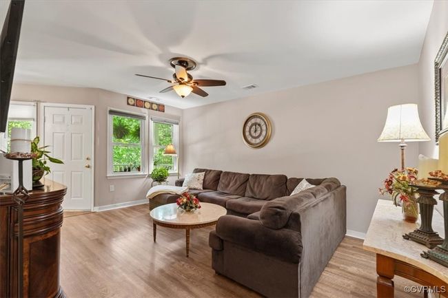 Living area with a ceiling fan, baseboards, and light wood-type flooring | Image 9