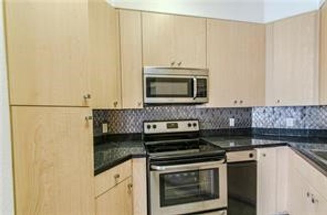 Kitchen with decorative backsplash, dark countertops, and Double Sink | Image 30