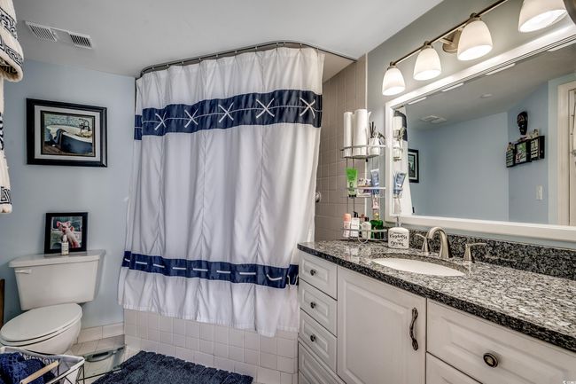 Bathroom featuring toilet, vanity, and tile patterned floors | Image 16