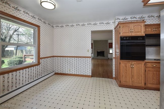 Kitchen with wallpapered walls, a wealth of natural light, oven, and baseboard heating | Image 28