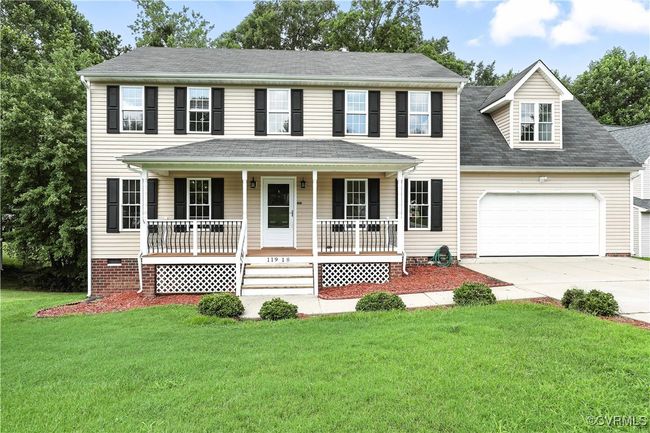 Colonial inspired home featuring concrete driveway, a garage, covered porch | Image 32