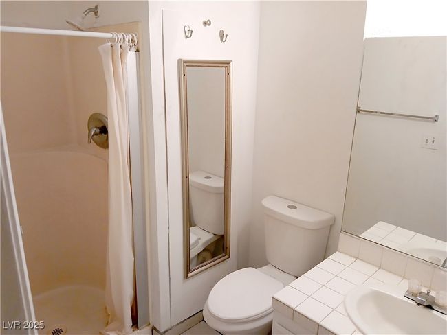 Full bath featuring curtained shower and vanity | Image 12
