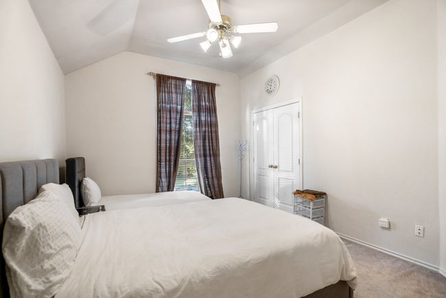 Carpeted bedroom with lofted ceiling and a ceiling fan | Image 25