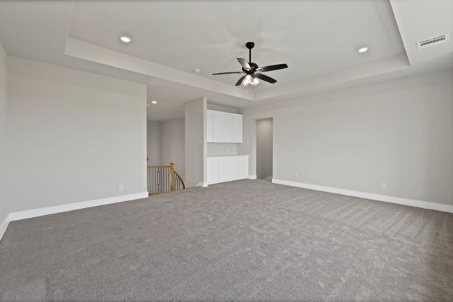 Carpeted spare room featuring a raised ceiling, recessed lighting, and ceiling fan | Image 24
