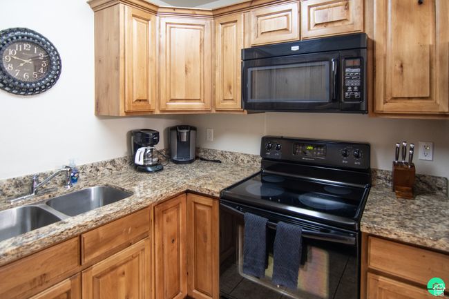 Kitchen with black appliances and light stone counters | Image 8
