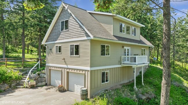 View of side of property featuring asphalt driveway, an attached garage, and a balcony | Image 49