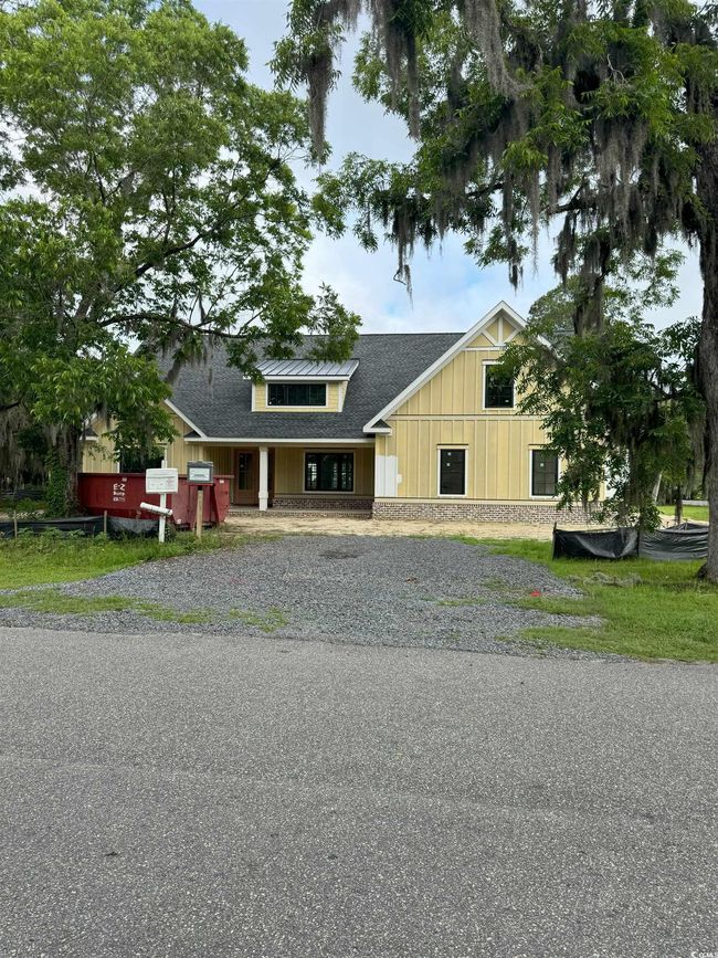 View of front of property with a shingled roof, gravel driveway, and board and batten siding | Image 5