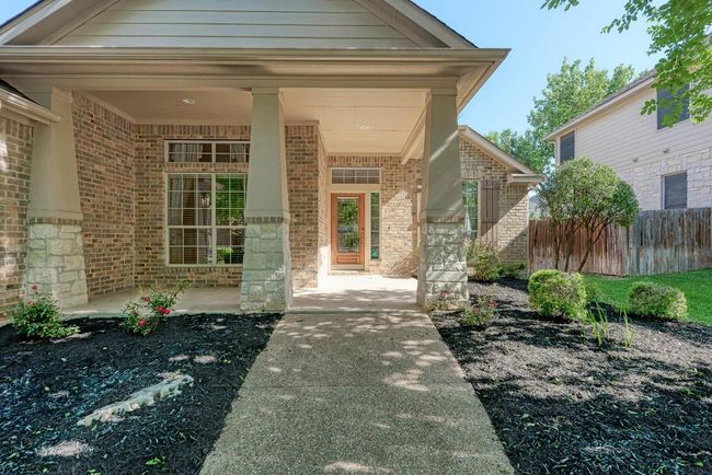 Property entrance with brick siding, a porch, and fence | Image 5
