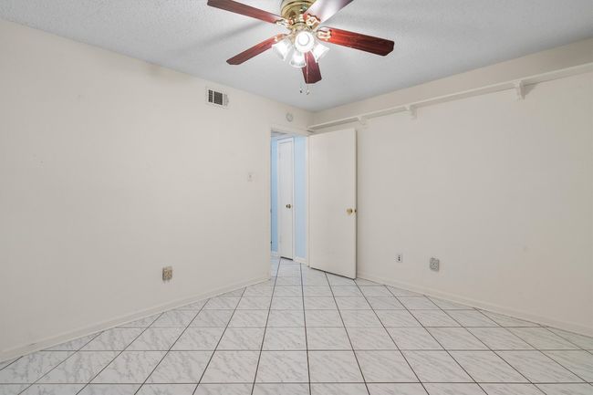 Spare room featuring a textured ceiling, ceiling fan, baseboards, and visible vents | Image 26