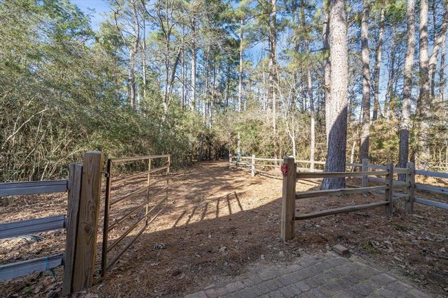 Private nature trails allow uninhibited exploration of this enchanting property and even diverge beyond the property boundaries into the rolling landscape of the family-friendly community. The trailhead is marked by this livestock gate. | Image 47