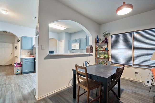 A large archway from the kitchen overlooks the dining and living with a corner fireplace with tile surround. | Image 13
