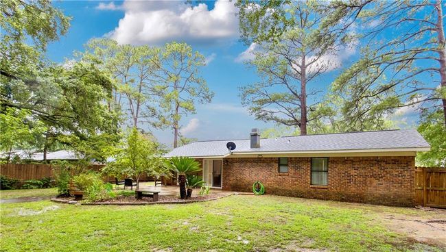 Back of house featuring a patio area, a chimney, and brick siding | Image 16