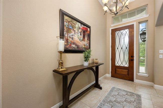Entryway featuring a chandelier, healthy amount of natural light, and light tile patterned floors | Image 5