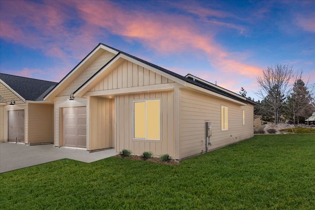 View of side of property featuring an attached garage, concrete driveway, board and batten siding, roof with shingles, and a yard | Image 25