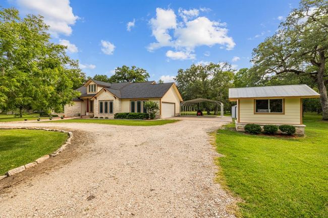 Elegant balance of living quarters and practical outbuildings: two-car oversized attached garage, storage shed, 2+ car carport for covered parking, and a custom built wellhouse to match the Home. | Image 6