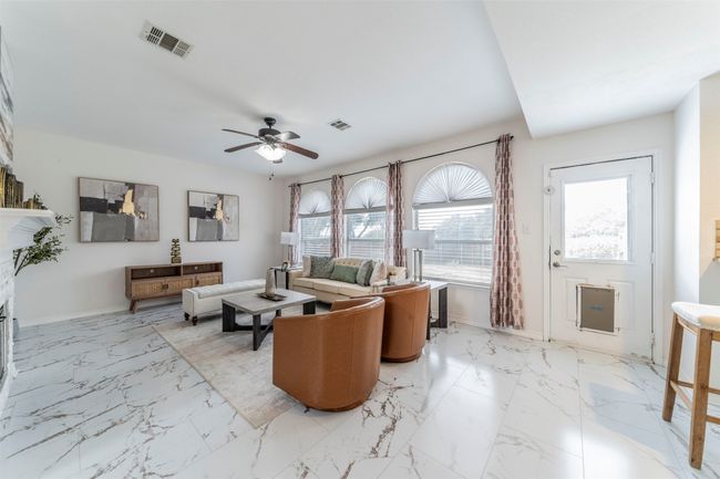 Living area featuring a ceiling fan and light marble finish floors | Image 4