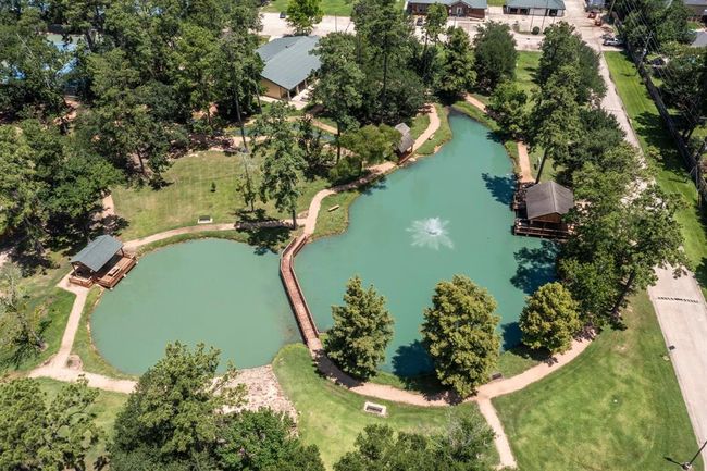 Aerial photo showcases the beautifully landscaped lake, complete with a central fountain and two gazebo-style structures. | Image 42