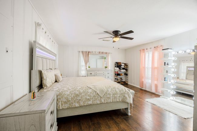 Bedroom featuring ceiling fan, dark wood finished floors, and visible vents | Image 17