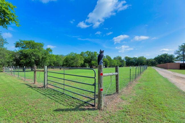 View of yard with a view of rural / pastoral area, dirt driveway, and a gate | Image 9