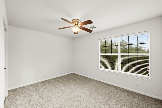 Carpeted empty room featuring a ceiling fan and baseboards | Image 14