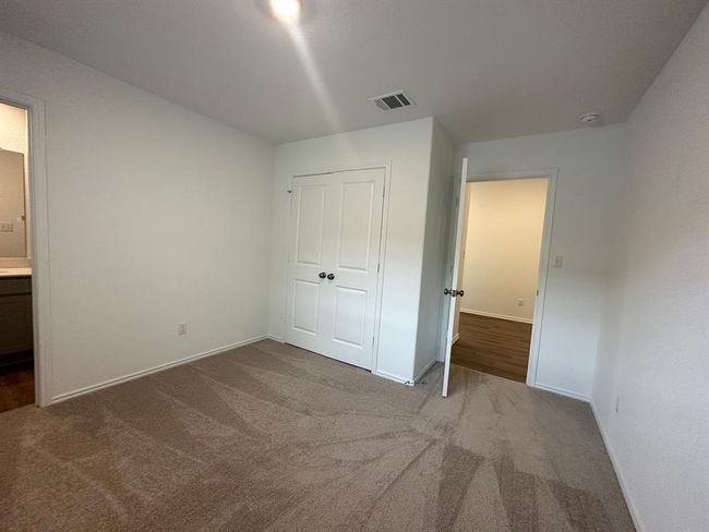 Unfurnished bedroom featuring carpet flooring, baseboards, a closet, and ensuite bathroom | Image 10