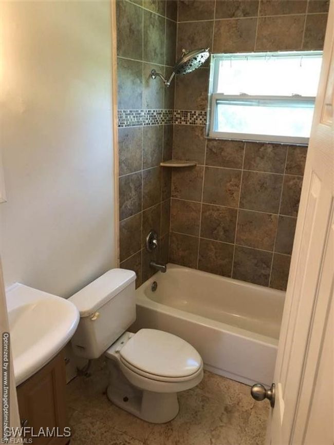Full bathroom with tile patterned floors, vanity, tiled shower / bath combo, and toilet | Image 10