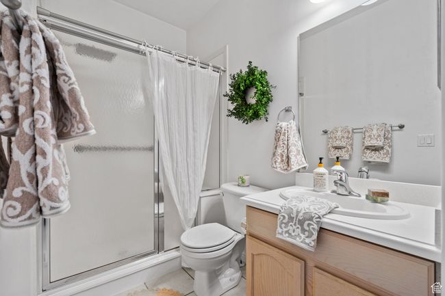 Bathroom with toilet, a shower stall, tile patterned flooring, and vanity | Image 26