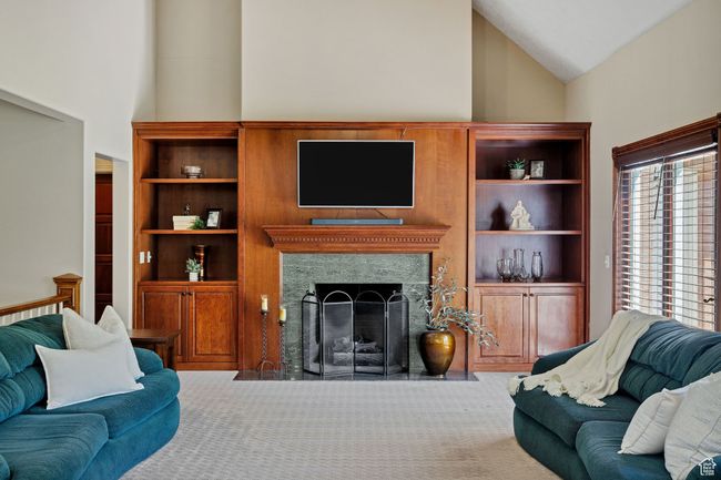 Carpeted living area featuring high vaulted ceiling and a high end fireplace | Image 23