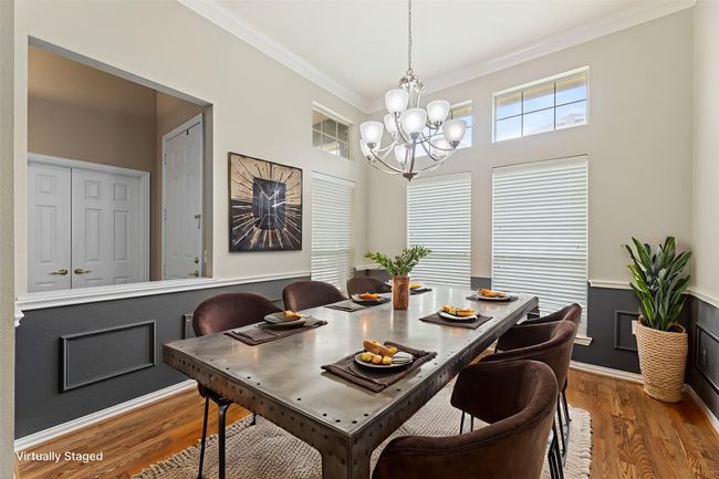 Dining space featuring ornamental molding, a chandelier, and wood finished floors | Image 8