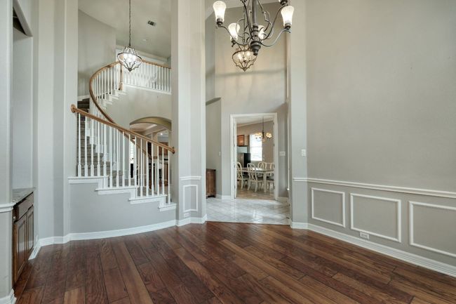 Entrance foyer featuring stairway, a towering ceiling, hardwood / wood-style flooring, and a notable chandelier | Image 6