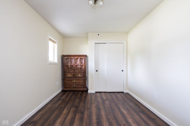 unfurnished bedroom with dark wood finished floors and a closet | Image 21
