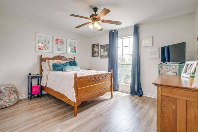 Bedroom with light wood like finished floors and ceiling fan | Image 29