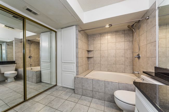 Full bathroom with tile patterned floors, vanity, tiled shower / bath combo, toilet, and visible vents | Image 7