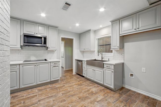 Grey shaker-style cabinets and white subway tile lend a fresh, contemporary feel that perfectly complements the kitchen’s warm, welcoming tone. | Image 6